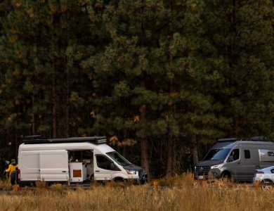 A couple of vans parked next to each other in a field