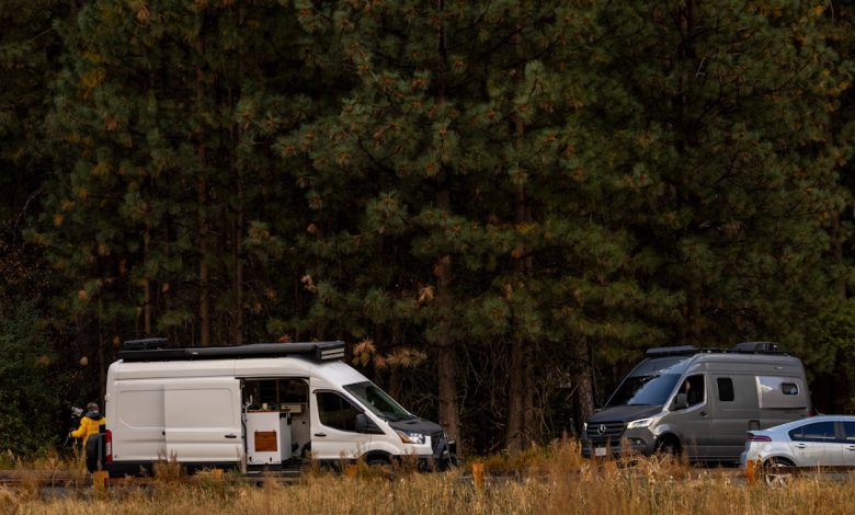 A couple of vans parked next to each other in a field