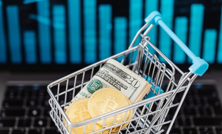 Symbolic image of cryptocurrency and cash in a shopping cart on a laptop, representing digital finance and trading.