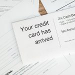Close-up of a letter announcing the arrival of a credit card amidst financial documents.