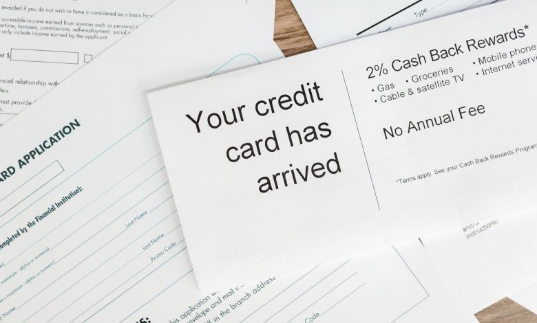 Close-up of a letter announcing the arrival of a credit card amidst financial documents.