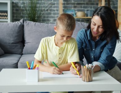 Mother and son drawing together at a table.