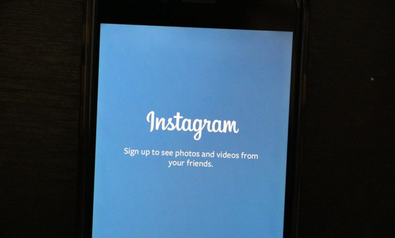 Close-up of a smartphone displaying the Instagram app welcome screen, inviting users to sign up.