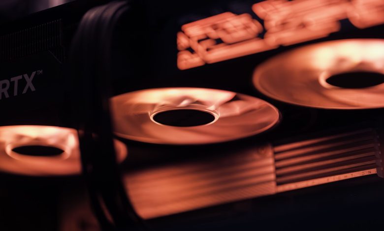 Dynamic close-up shot of illuminated gaming graphics card fans in red light, showcasing cutting-edge technology.