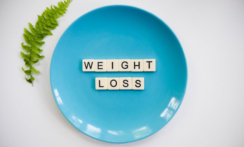 A blue plate with 'weight loss' tiles and a fern leaf on white background.