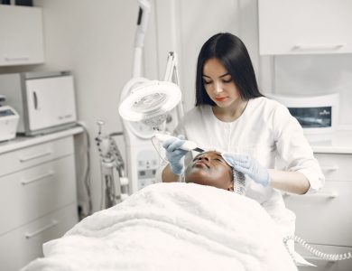 Aesthetician providing a rejuvenating facial treatment to a client in a modern spa clinic setup.