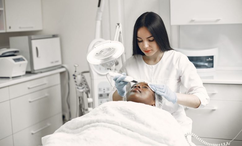 Aesthetician providing a rejuvenating facial treatment to a client in a modern spa clinic setup.