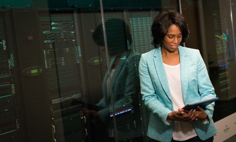 Female IT professional examining data servers in a modern data center setting.