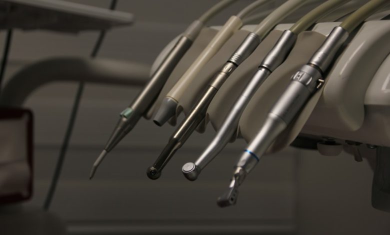 a row of dental instruments hanging from a wall