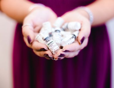 Close-up of a woman's hands holding multiple medical vials, emphasizing healthcare and cosmetic treatment.