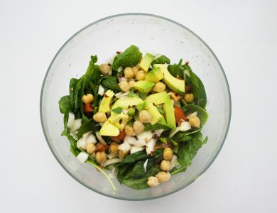 A bowl of salad with vegetables arranged for a balanced meal.