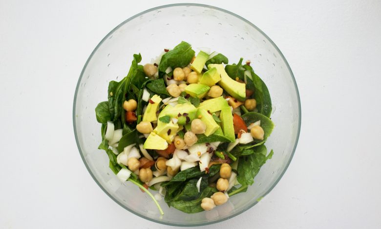 A bowl of salad with vegetables arranged for a balanced meal.