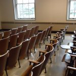An empty university classroom with chairs, desks and a blackboard.